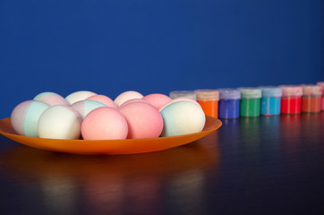painted Easter eggs and paints on the table. preparation for Easter. wooden table.
