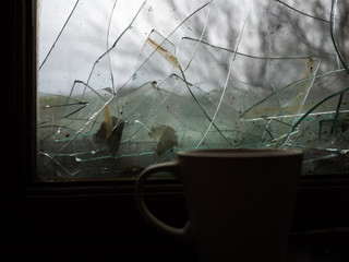 Mug on a window sill at the broken window. The abandoned building