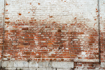 The texture of the old brick wall painted white with peeling paint