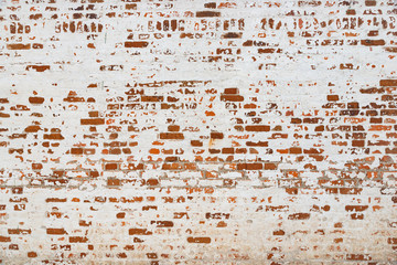 La texture du vieux mur de briques peint en blanc avec de la peinture écaillée