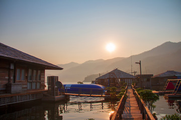 Soft sunlight in the morning with wooden floating bridge, the lake and mountain view for time of freedom on the floating home stay.