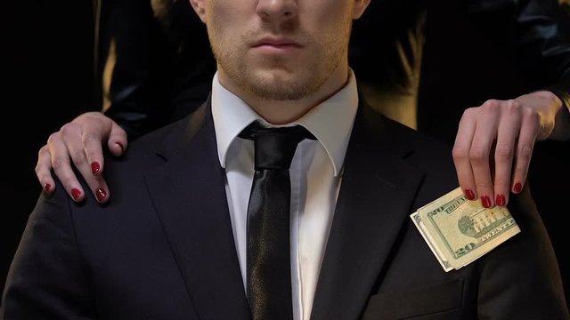 Tricky woman secretly taking money from male suit, manipulating husband, closeup