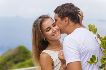 Fototapeta premium Young couple on a journey, walk through the island’s viewpoint, romance, kisses