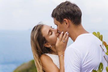 Fototapeta premium Young couple on a journey, walk through the island’s viewpoint, romance, kisses