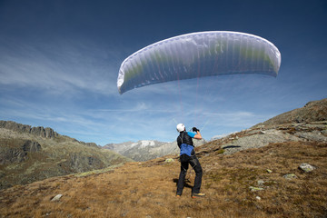 Young paraglider pilot uses his paraglider to play with the wind in the Swiss Alps, the so-called...