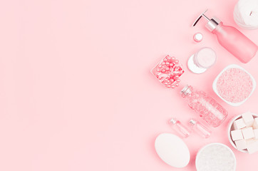 Obraz na płótnie Canvas Cosmetics for salon aromatherapy, massage or bathroom - bath salt, cream, essential oil, soap, bowls, bottles, jewelry on elegance pink background.