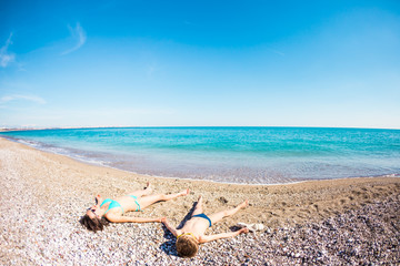 Fototapeta na wymiar The boy with his mother sunbathe on the beach.