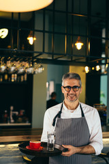 Order is ready. waiter holding plate with coffee and water in cafe bar