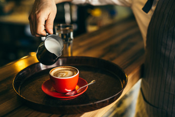 pouring milk into espresso coffee