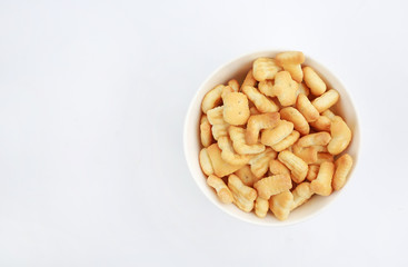 Cracker or Cookie ABC letter alphabet in bowl with copy space on white background.