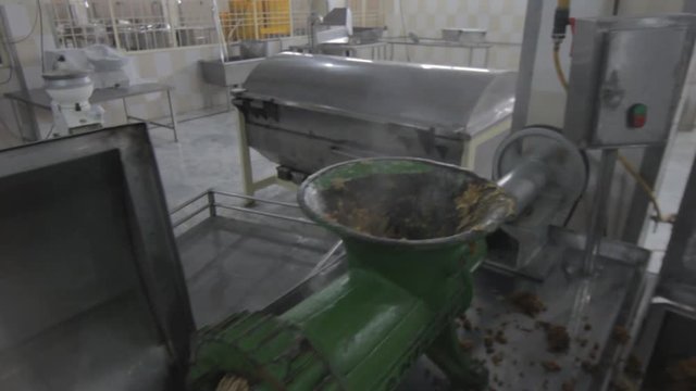 Ready Meal Production line in a factory, A man shifting cooked rice into a machine that mincing it