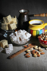 A mug of coffee and different oriental sweets: turkish delight, halva, almond and pistachio