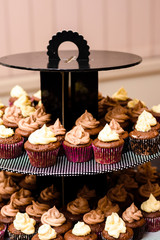 Colorful cupcakes with icing on decoration table.