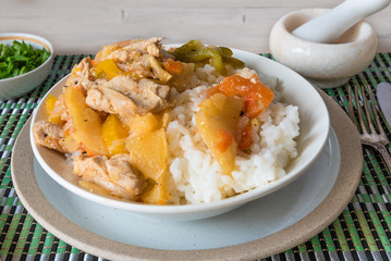 Chicken and apple curry with rice in a bowl on a bamboo napkin - Asian cuisine.