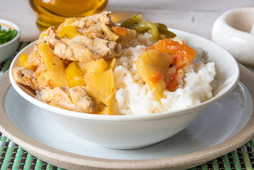 Chicken and apple curry with rice in a bowl on a bamboo napkin - Asian cuisine.