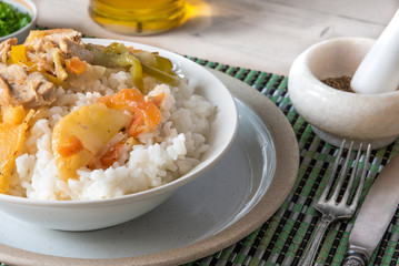Chicken and apple curry with rice in a bowl on a bamboo napkin - Asian cuisine.