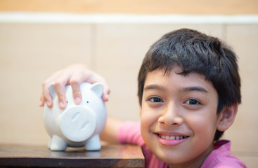 Little boy save money in piggy bank