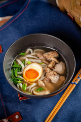 Pan-Asian cuisine concept. Japanese Ramen Soup with Chinese Noodles, Egg, Chicken and Green Onions. Serving dishes in the restaurant in the bowl. Background image. copy space