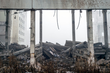The remains of a large building destroyed in a foggy haze. Background.