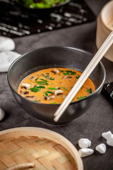 Pan-Asian cuisine concept. Japanese miso soup Tom Yam Kung with seafood, shrimps, mussels, calamari. Serving dishes in the restaurant in the bowl. Background image.