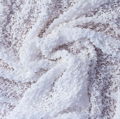 textured background of white fabric twisted into a spiral.close up