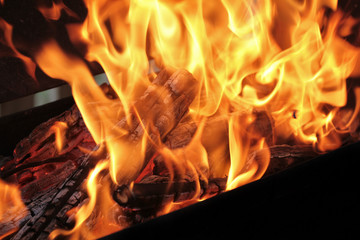 A shot of burning firewood in the fireplace. Close-up. Burning wood for a barbecue. Smoke and...