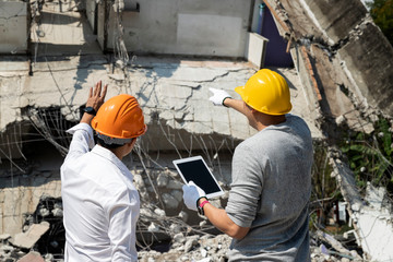 Demolition control supervisor and foreman discussing on demolish building.