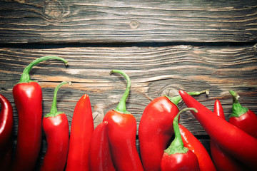 Red hot chili peppers on wood background