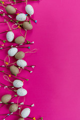 Obraz premium Easter decor. The branches of willow and decorative eggs are laid out on a pink background
