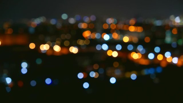 Flickering distant city lights in soft focus create a dreamy abstract bokeh effect