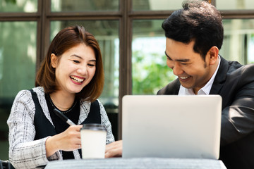 Business woman sitting at cafe outdoor and discussing with her team.