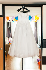 wedding dress on a hanger on a mirror closet