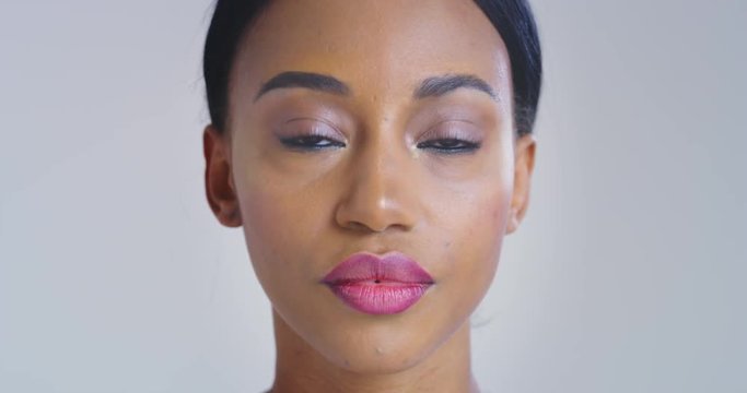 Slow motion close up of african woman with beautiful face with perfect skin just cleaned from impurities ready for day or night cream is smiling in camera. 