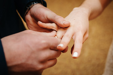 the groom puts the ring on the bride's finger