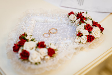 wedding rings on a heart-shaped pillow