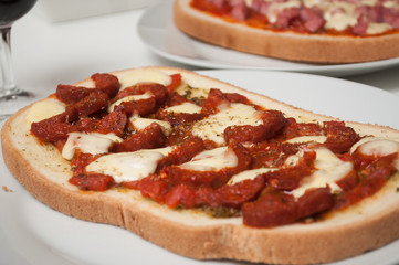 closeup of homemade Bruschetta with chorizo in a white plate