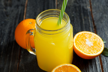 Fresh bright homemade orange juice on wooden table close up