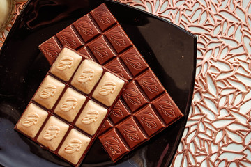 Chocolate bar on a black plate. Top view. Black and white chocolate.