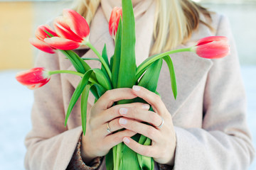 Tulips in female hands. Spring beautiful composition with blurred background.