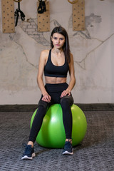 The girl is engaged on a fitness ball in the gym