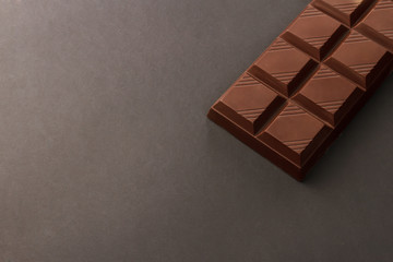Chocolate bar on black dark background. Milk chocolate bar on dark background