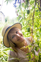 Portrait of beautiful blonde woman in hat in summer garden