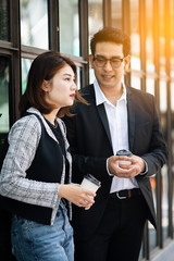 Business woman holding coffee cup and talking with her team outdoor.  Businessman lifestyle concept.