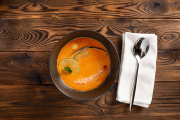 soup tom yam in a black plate on a wooden background