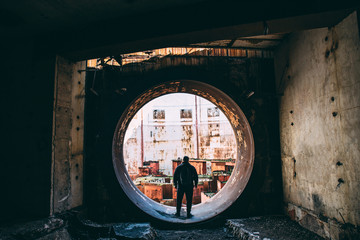 Man traveller and explorer inside round door or gate to abandoned nuclear rector or generator room...