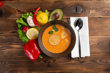 tom kha soup with lemon and vegetables on a wooden background