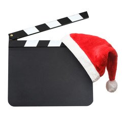 Santa hat hanging on blank movie clapper board. Christmas entertainment concept