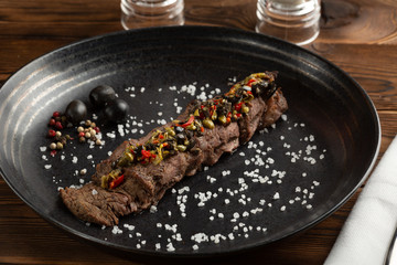 machete steak on black plate on wooden background
