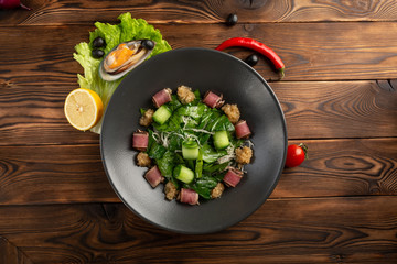 tuna salad with matsuhisa sauce on a wooden background