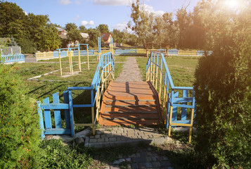 Fototapeta na wymiar Small wooden bridge on children playground. Summer sunny day.